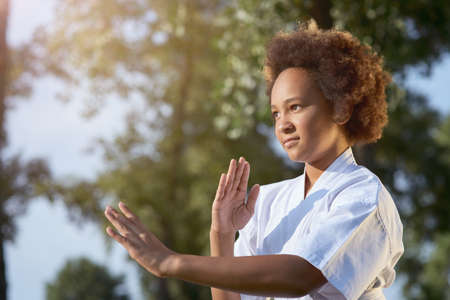 Adorable Afro American girl practicing karate on the streetの写真素材