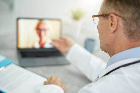 Doctor using laptop for online consultation in clinic