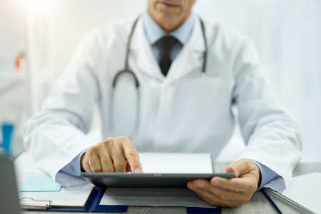 Male doctor using tablet computer at workの写真素材
