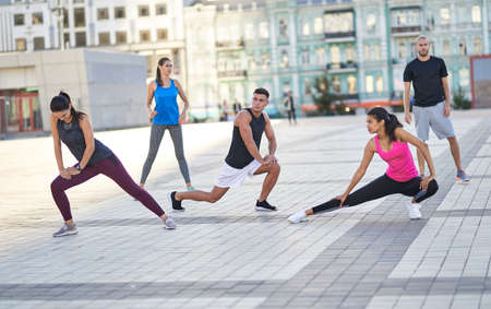 Athletic people warming up before jogging in the streetの写真素材