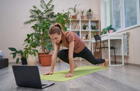 Beautiful lady doing sports online on self-isolationの写真素材