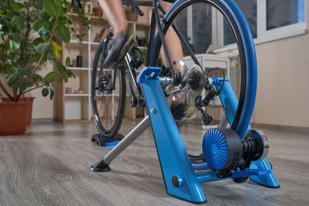 Man doing training on a cycle trainer at home