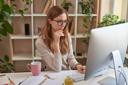 Serious woman working on the computer during quarantineの写真素材