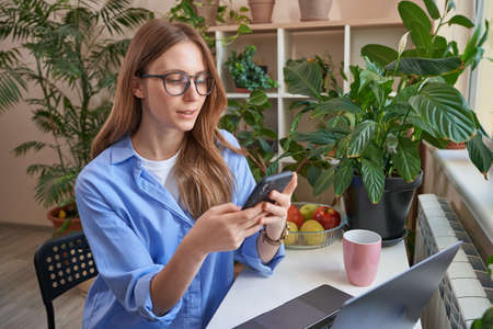 Beautiful lady using mobile phone and looking on screenの写真素材