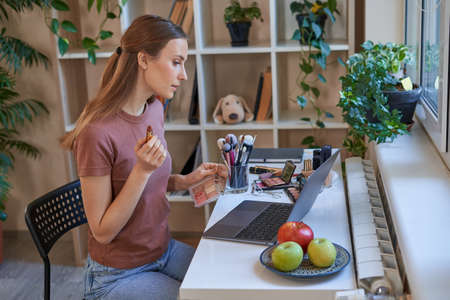 Female blogger during online makeup tutorials at homeの写真素材