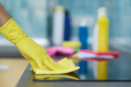 Quality cleaning. Close up shot of hand of man, professional male cleaner wearing gloves while...