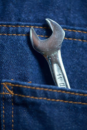 Close up shot of an adjustable wrench in mans jeans back pocketの写真素材