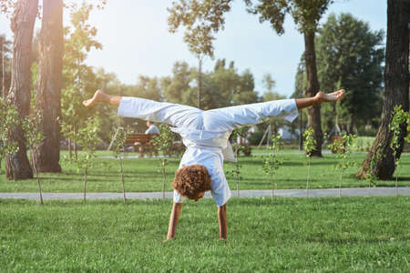 Sporty female child karateka doing handstand exercise outdoorsの写真素材