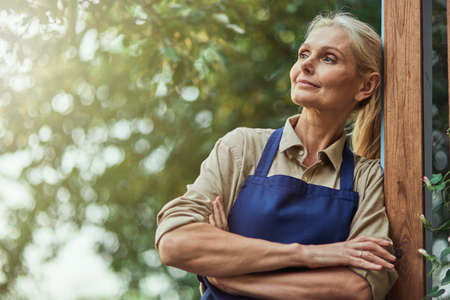 Middle aged caucasian woman looking sideways in gardenの写真素材