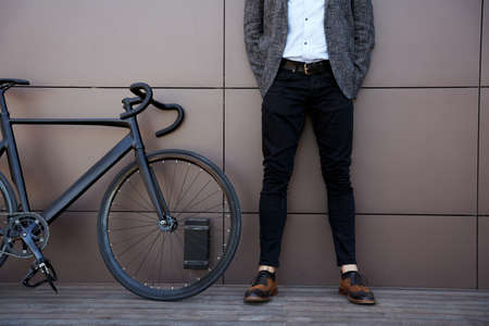Cropped shot of stylish middle aged guy standing outdoors with his bicycleの写真素材