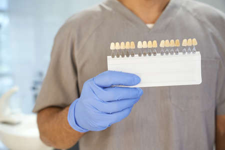 Dentist posing with teeth-whitening kit in his officeの写真素材