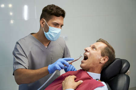 Certified dentist treating his patient at the clinicの写真素材