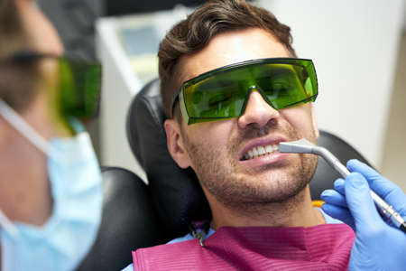 Male patient of dental clinic receiving professional treatmentの写真素材