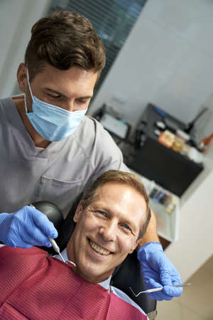 Positive man looking at camera at dental clinicの写真素材