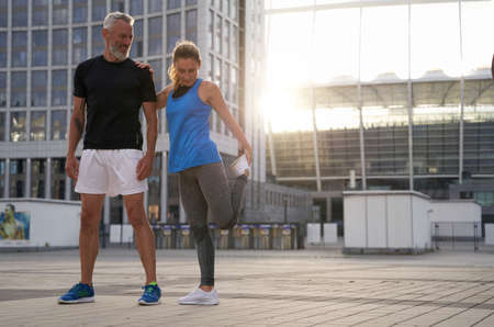Full length shot of sporty mature couple, man and woman ready for exercising together in the city on a summer dayの写真素材