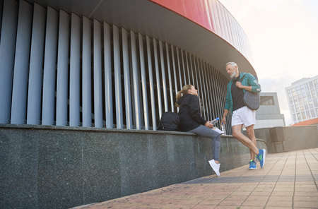 Active mature couple, man and woman in sportswear having a conversation outdoors while waiting together for workoutの写真素材