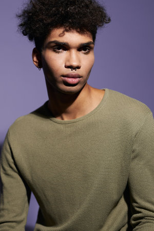 Close up portrait of brunette african american transgender male with afro hairstyle in studioの写真素材