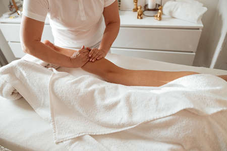 Young woman receiving therapeutic massage at wellness centerの写真素材