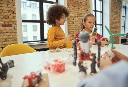 Logical analysis. Cute little boy and girl making robots during STEM classの写真素材