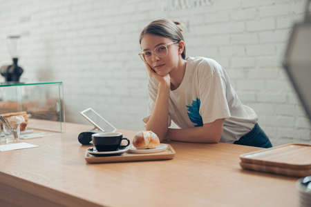 Charming young woman working in coffee shopの写真素材