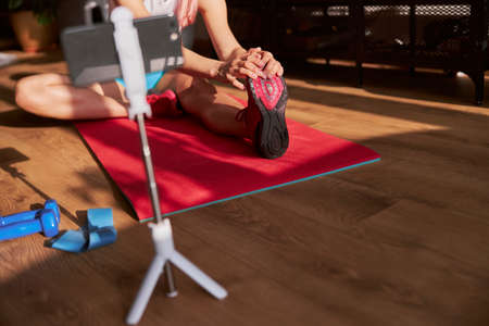 Young woman shoots new video showing head to knee while sitting on floor at home closeupの写真素材