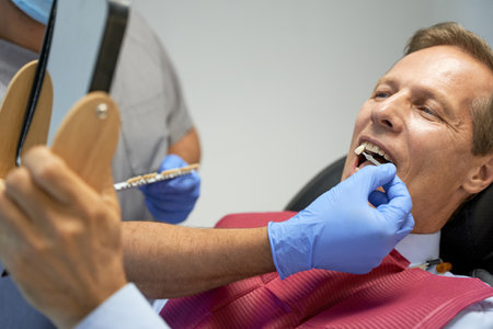 Fragment photo of middle-aged man doing teeth-whitening in clinicの写真素材
