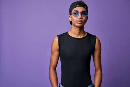 Horizontal portrait of young transgender man in black t-shirt, blue sunglasses. Latino trans genderの写真素材