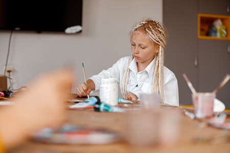 Kid learning to paint with watercolors at schoolの写真素材
