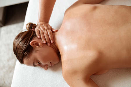 Beautiful woman receiving professional massage in spa salon