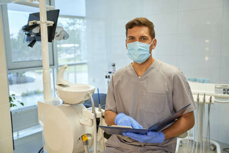 Friendly personnel of dental clinic posing with list of patientsの写真素材
