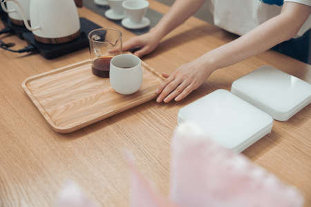 Female barista serving delicious coffee in cafeteriaの写真素材