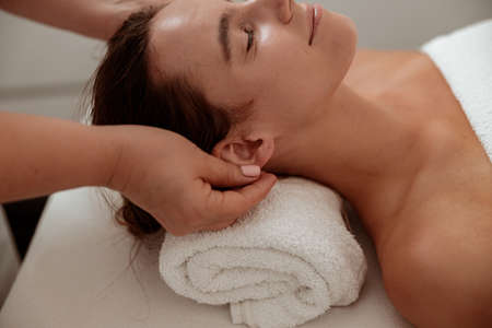 Beautiful young woman receiving professional massage in spa salonの写真素材
