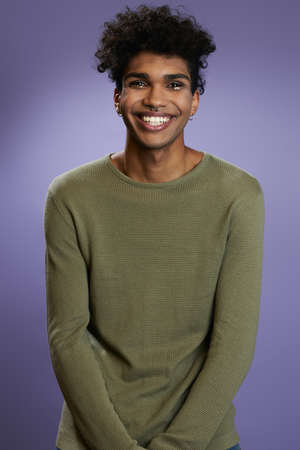 Portrait of transgender brunette model in olive t-shirt looks camera and smileの写真素材