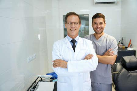 Two male dentists smiling and looking professionalの写真素材