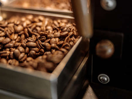 Industrial coffee roasting machine with roasted coffee beansの写真素材