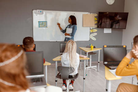 Female teacher teaching kids in classroom at schoolの写真素材