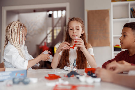 Boy and girls constructing model with constructor details in schoolの写真素材