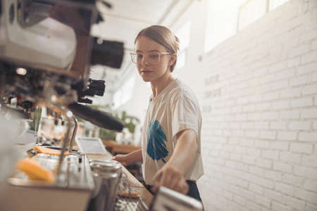 Beautiful young woman barista working in coffee shopの写真素材