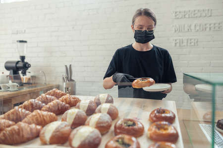 Female person putting baked goods on snowcaseの写真素材