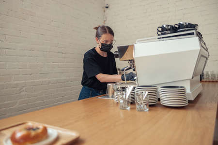 Professional barista preparing latte in coffee shopの写真素材