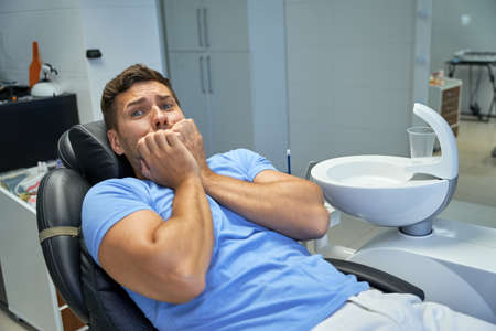 Scared male patient anticipating a dental check-upの写真素材