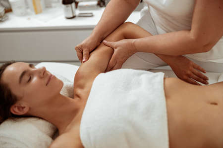 Beautiful young woman receiving professional massage in spa salonの写真素材