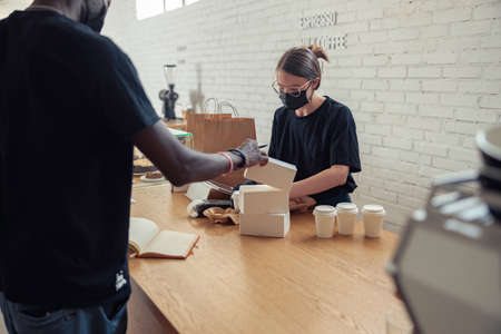 Woman is working in coffeehouse in covid-19の写真素材