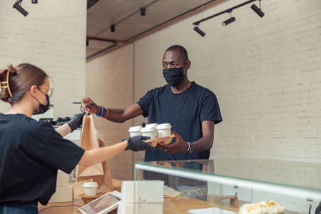 Male person in black mask delivering packages on addressの写真素材