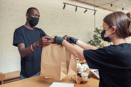 Barista transfering orders of visitors to courierの写真素材