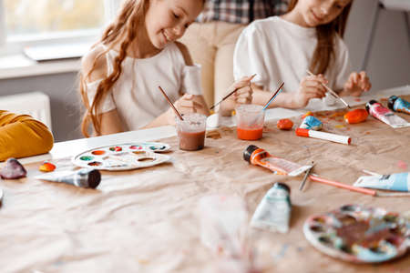 Smiling schoolgirls making art painting using water colorsの写真素材