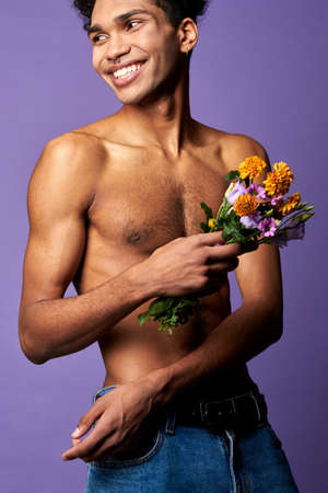 Smiling athletic transgender man with flowers close-up portrait shot. Naked torso sportsmanの写真素材