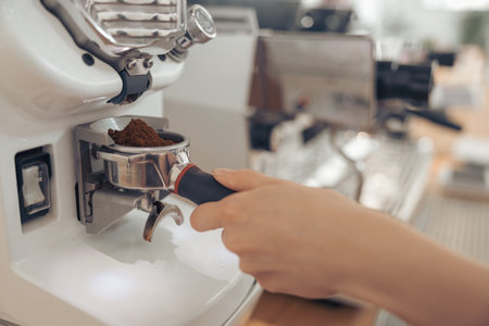 Female barista hand using professional coffee machine in cafeteriaの写真素材