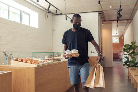 Black man going with orders of people on corridorの写真素材