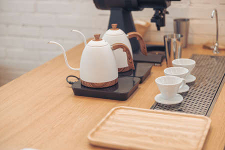 Wooden counter with kettles, coffee cups and tray in cafeteriaの写真素材